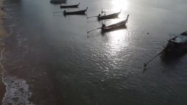 Aerial view from drones of fishing boats in the shore during low tide. Top view of many Thai traditional longtail fishing boats in the tropical islands. A lot of long tail boat on sea