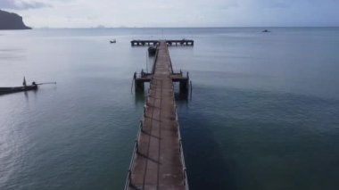 Aerial view from a drone of a pier in a tropical sea. A lot of Thai traditional longtail fishing boats in the southern island of Thailand.
