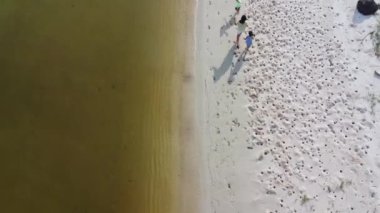 Aerial view from a drone of a happy Asian family of mother and daughters having fun playing on the beach during summer vacation. Summer family trip to the beach. travel and vacation concept.