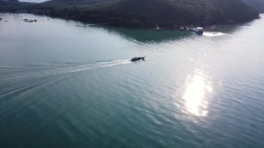 Luxury yachts or ferries sail in the Andaman Sea from Koh Yao Yai to the pier in Phuket, Thailand. Travel and transportation concept.