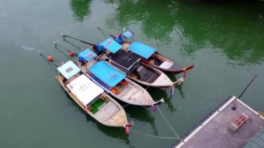 Aerial view from drone of Ao Thalane Pier with many fishing boats moored. Top view of many Thai traditional longtail boats floating in the mangrove landscape. Transportation and travel concept.