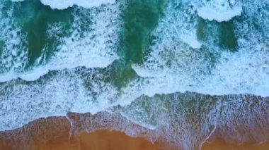Beautiful sea waves and white sand beach in the tropical island. Soft waves of blue ocean on sandy beach background from top view from drones. Concept of relaxation and travel on vacation.