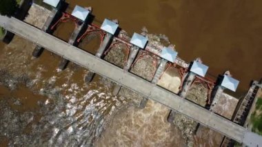 Aerial view of water released from the drainage channel of the concrete dam is a way of overflowing water in the rainy season. Top view of turbid brown forest water flows from a dam in rural northern Thailand.