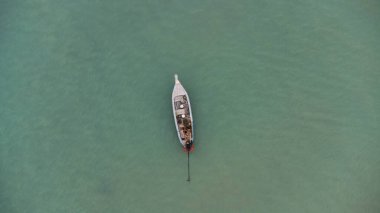 Aerial view from a drone of Thai traditional longtail fishing boats sailing in the sea. Top view of a fishing boat in the ocean.
