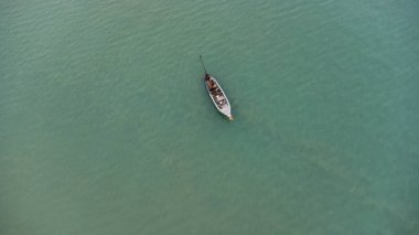 Aerial view from a drone of Thai traditional longtail fishing boats sailing in the sea. Top view of a fishing boat in the ocean.