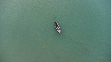 Aerial view from a drone of Thai traditional longtail fishing boats sailing in the sea. Top view of a fishing boat in the ocean.