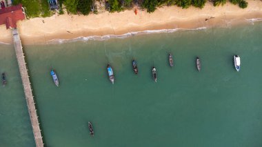 Many fishing boats near the seashore in tropical islands. Pier of the villagers on the southern island of Thailand. top view from drones.