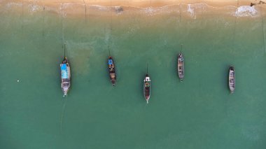 Many fishing boats near the seashore in tropical islands. Pier of the villagers on the southern island of Thailand. top view from drones.