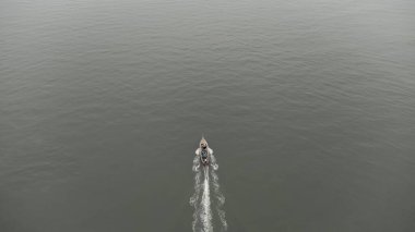 Aerial view from a drone of Thai traditional longtail fishing boats sailing in the sea. Top view of a fast moving fishing boat in the ocean.