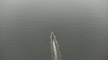 Aerial view from a drone of Thai traditional longtail fishing boats sailing in the sea. Top view of a fast moving fishing boat in the ocean.