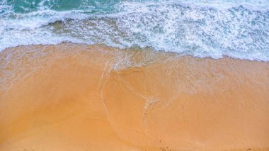 Beautiful sea waves and white sand beach in the tropical island. Soft waves of blue ocean on sandy beach background from top view from drones. Concept of relaxation and travel on vacation.