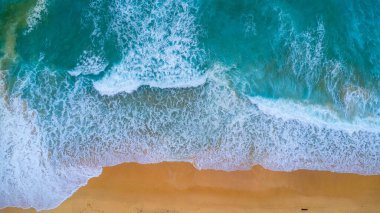 Beautiful sea waves and white sand beach in the tropical island. Soft waves of blue ocean on sandy beach background from top view from drones. Concept of relaxation and travel on vacation.