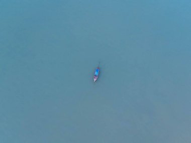 Aerial view from a drone of Thai traditional longtail fishing boats sailing in the sea. Top view of a fishing boat in the ocean.