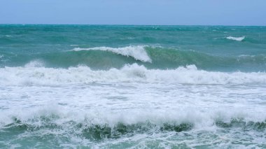 Beautiful ocean waves with blue and turquoise foam on a hot summer day.