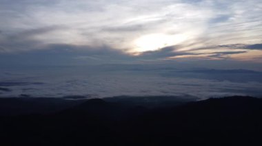 Sabahın erken saatlerinde tropikal dağlardaki sis denizinin havadan görünüşü. Tayland 'daki dağların katmanları. Doğanın hareketli arka planının manzarası.