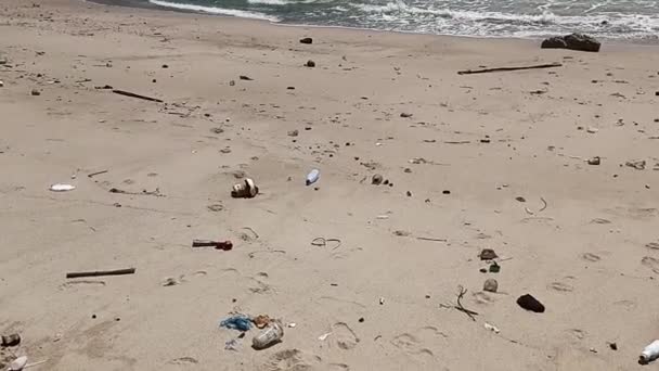 一个女人赤着脚走在沙滩上 沙滩上满是垃圾 干枯的树枝 到处都是塑料 人为地把垃圾倒在海滩沙地上的问题 环境和生态概念 — 图库视频影像
