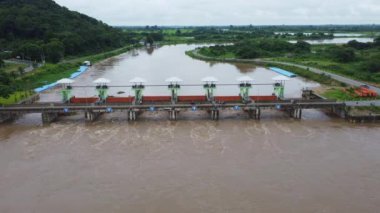 Yağmur mevsimindeki taşkınlık olarak beton barajın drenaj kanalından çıkan suyun hava görüntüsü. Kuzey Tayland 'daki bir barajdan turbiş kahverengi orman suyunun en üst görüntüsü akıyor.
