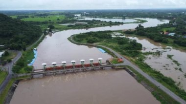 Yağmur mevsimindeki taşkınlık olarak beton barajın drenaj kanalından çıkan suyun hava görüntüsü. Kuzey Tayland 'daki bir barajdan turbiş kahverengi orman suyunun en üst görüntüsü akıyor.