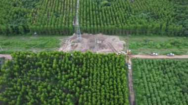 Kazıcıların hava görüntüsü, yüksek voltajlı direklerin temelleri ve yüksek voltajlı kutupların bacakları üzerinde çalışıyor. Ormandaki elektrik hatlarının en üst görüntüsü.