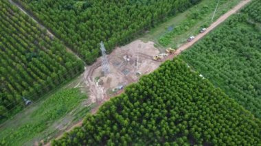 Kazıcıların hava görüntüsü, yüksek voltajlı direklerin temelleri ve yüksek voltajlı kutupların bacakları üzerinde çalışıyor. Ormandaki elektrik hatlarının en üst görüntüsü.