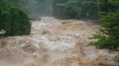 Orman dağlarında şelale kataraktı. Tayland 'da sağanak yağışlardan sonra dağ ormanlarının yamaçlarından kirli akarsular akıyor. Nehir taşkını, seçici odak.