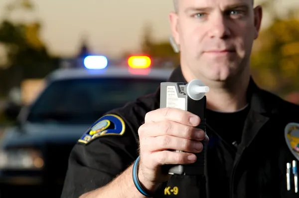 Un policier tient une machine d'alcootest — Photo