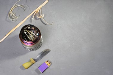 Açık hava piknikleri için taşınabilir katlanabilir yakıcı, bıçak ve kibrit, gri yüzeyde ateşleme için tahta talaşı ve fotokopi alanı.