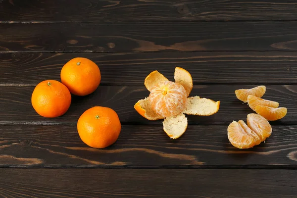 Whole Orange Tangerines Seen Peel Separate Juicy Slices Wooden Surface — стоковое фото