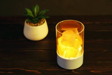 Gece lambası, Himalaya tuzu, ahşap karanlık yüzeyde parlayan sarı ışık.