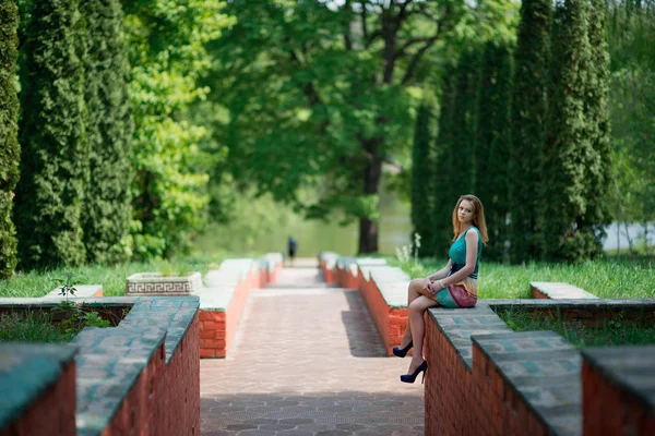 The young nice girl sits on a ladder protection — Stock Photo, Image