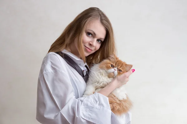 Het mooie meisje met een rode kat op handen — Stockfoto
