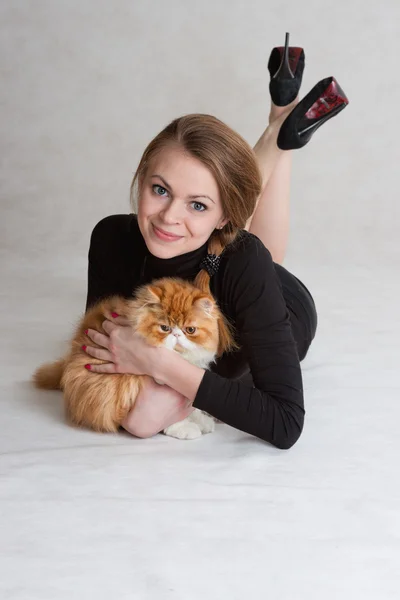 Pěkná dívka s červenou kočka na ruce — Stock fotografie