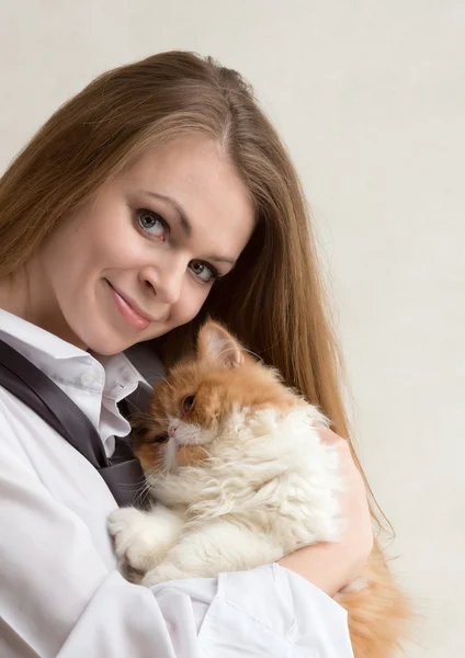 La buena chica con un gato rojo en las manos — Foto de Stock