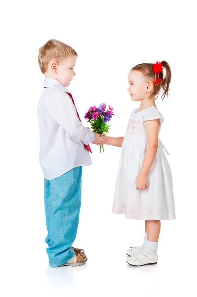 Kleiner Junge schenkt Freundin Blumen — Stockfoto