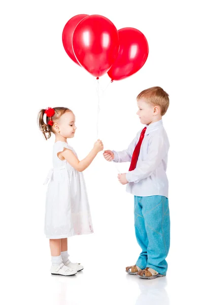 Menino e menina com os balões vermelhos — Fotografia de Stock