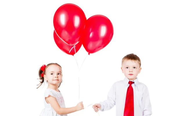 Niño y niña con los globos rojos —  Fotos de Stock