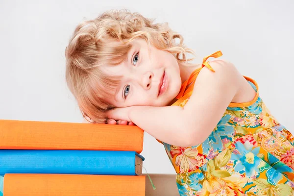 Menina bonita com livros, em um fundo cinza — Fotografia de Stock