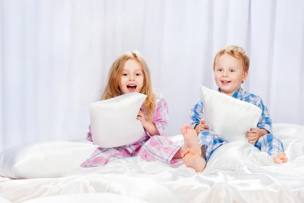 Deux enfants joyeux jouant sur le lit — Photo