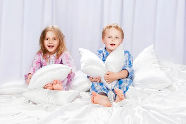 Deux enfants joyeux jouant sur le lit — Photo