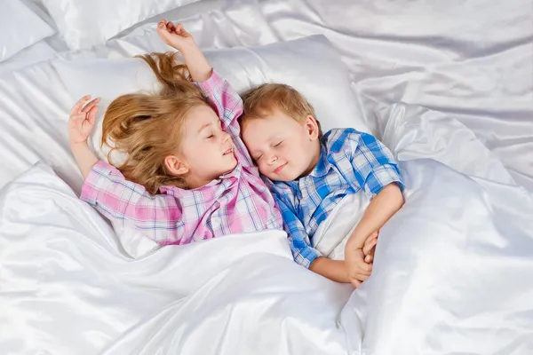 Menino e menina feliz na cama — Fotografia de Stock