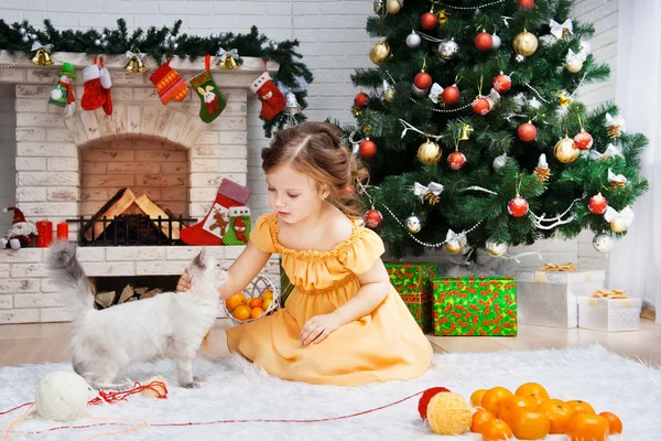 Kleines Mädchen mit Katze im Ferienzimmer — Stockfoto