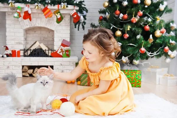 Kleines Mädchen mit Katze im Ferienzimmer — Stockfoto