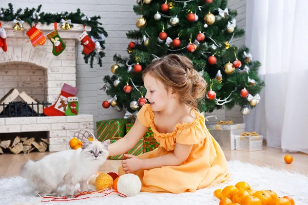 Kleines Mädchen mit Katze im Ferienzimmer — Stockfoto