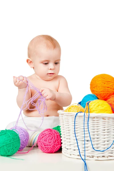 Bébé joue avec des boules de fil colorées — Photo