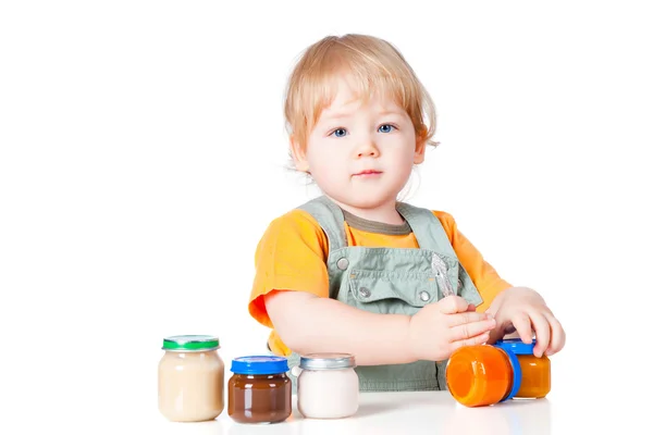 Menino com pequenos frascos de comida de bebê — Fotografia de Stock