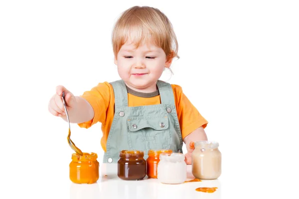 Мальчик с маленькими банками детского питания — стоковое фото