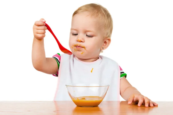 Criança come com uma colher — Fotografia de Stock