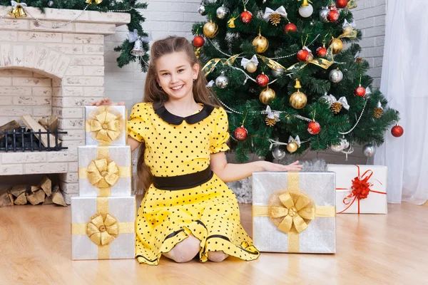 Kleines Mädchen in einem Zimmer mit Weihnachtsgeschenken — Stockfoto