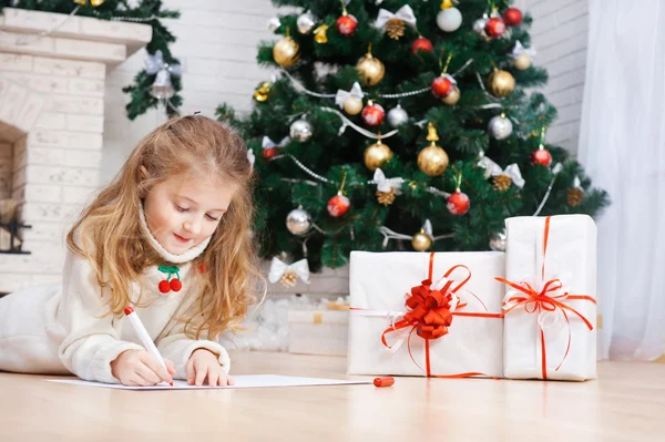 Little girl in a room with Christmas gifts — Stock Photo, Image
