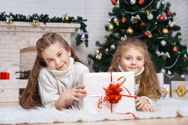 Zwei kleine Mädchen in einem Raum mit Weihnachtsgeschenken — Stockfoto